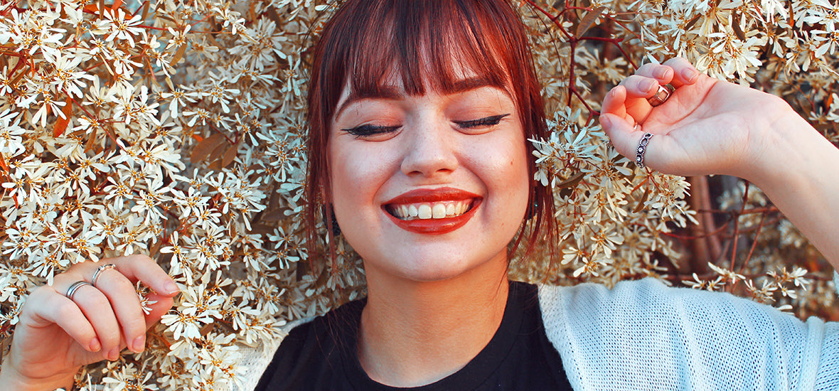 Smiling woman lying on flowers with smooth skin from ginseng for skin.