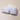 Grey bamboo eye mask resting on a stone plinth on neutral background