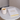 Lit candle in ceramic holder and 'My Daily Self Care Journal' on a round table with a neutral background